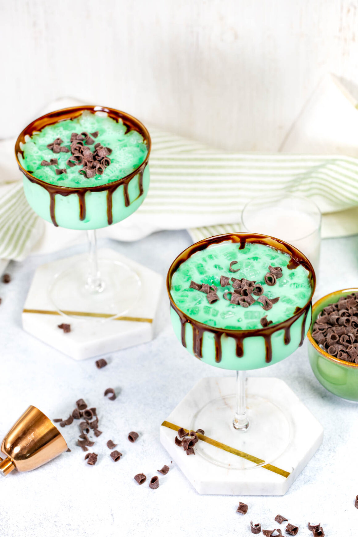 2 martini glasses with green liquid, rim it with chocolate 