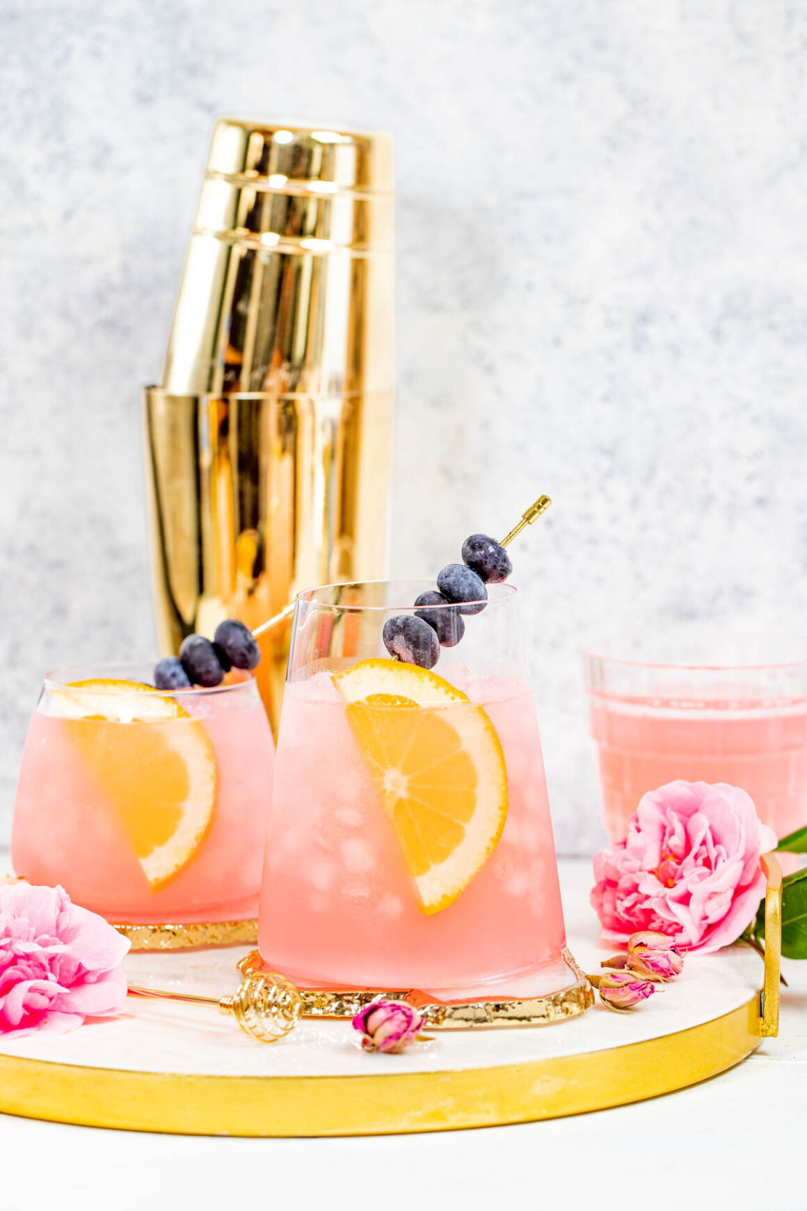 2 rose cocktail recipes with a blueberries skewer as a garnish