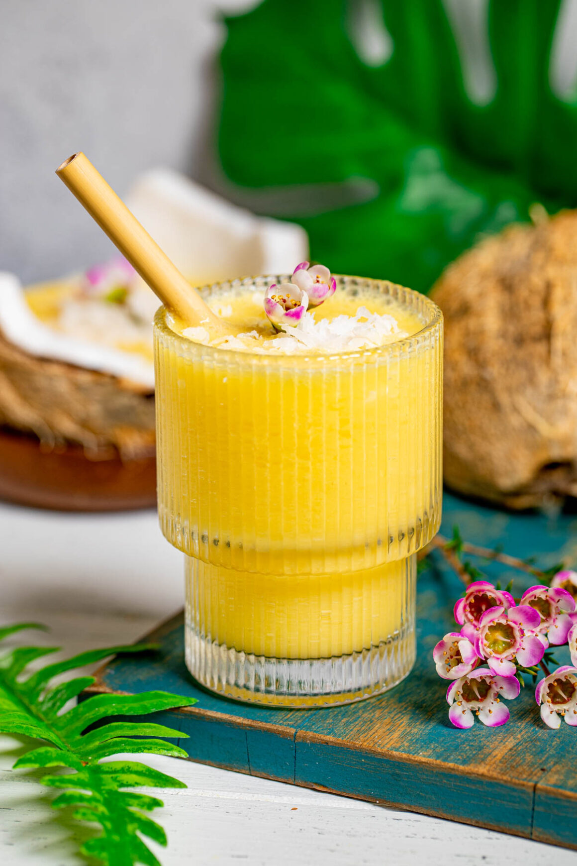 short glass with a mango coconut smoothie
