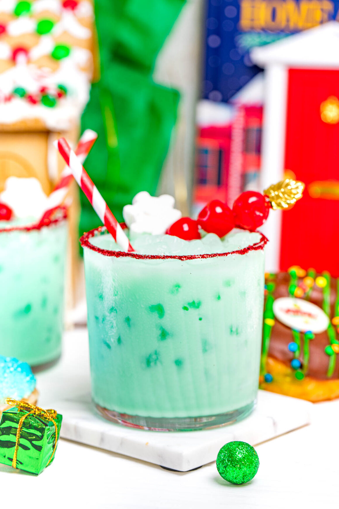 2 grinch cocktail recipes with a chocolate donut on the side for decoration