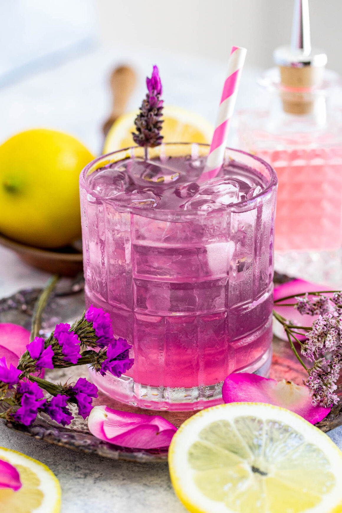 old fashioned glass of a lavender cocktail with a purple color serve with ice