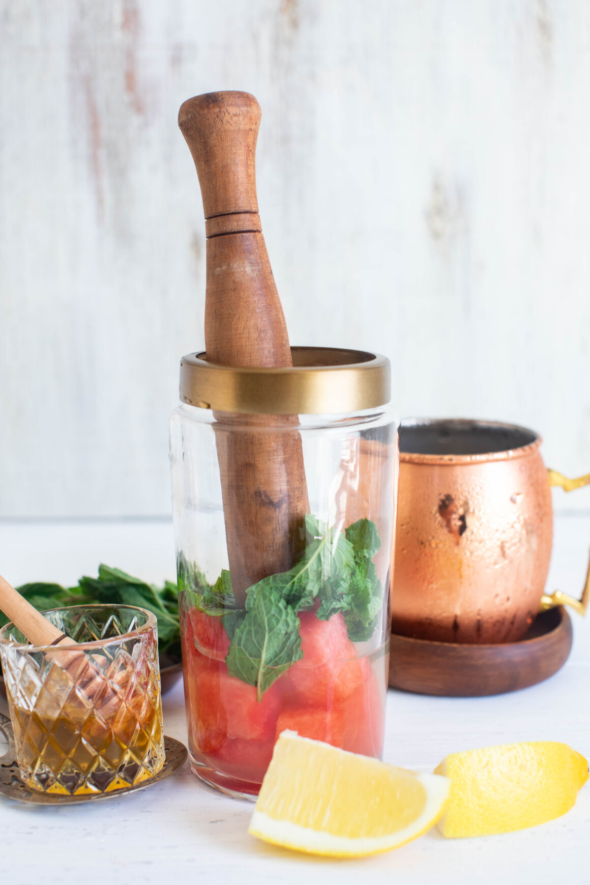 macerating watermelon, mint and lemon juice in a cocktail shaker